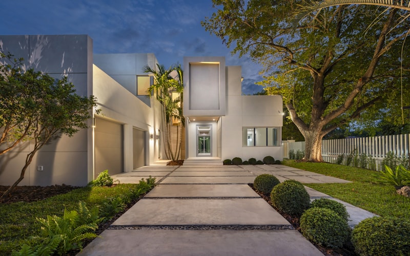 Modern home with illuminated pathway and professional outdoor lighting at dusk