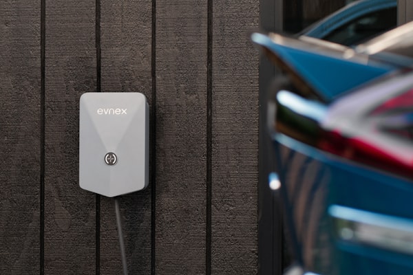 EV charging station mounted on wall with vehicle nearby